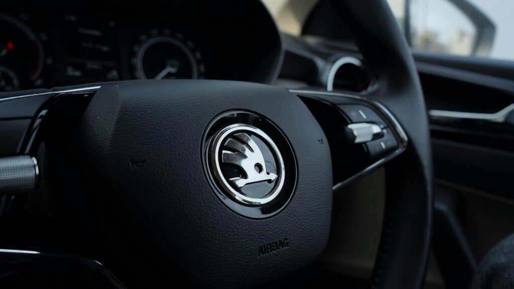 Detailed view of a Skoda steering wheel inside a vehicle, showcasing modern car design.