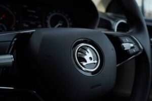 Detailed view of a Skoda steering wheel inside a vehicle, showcasing modern car design.